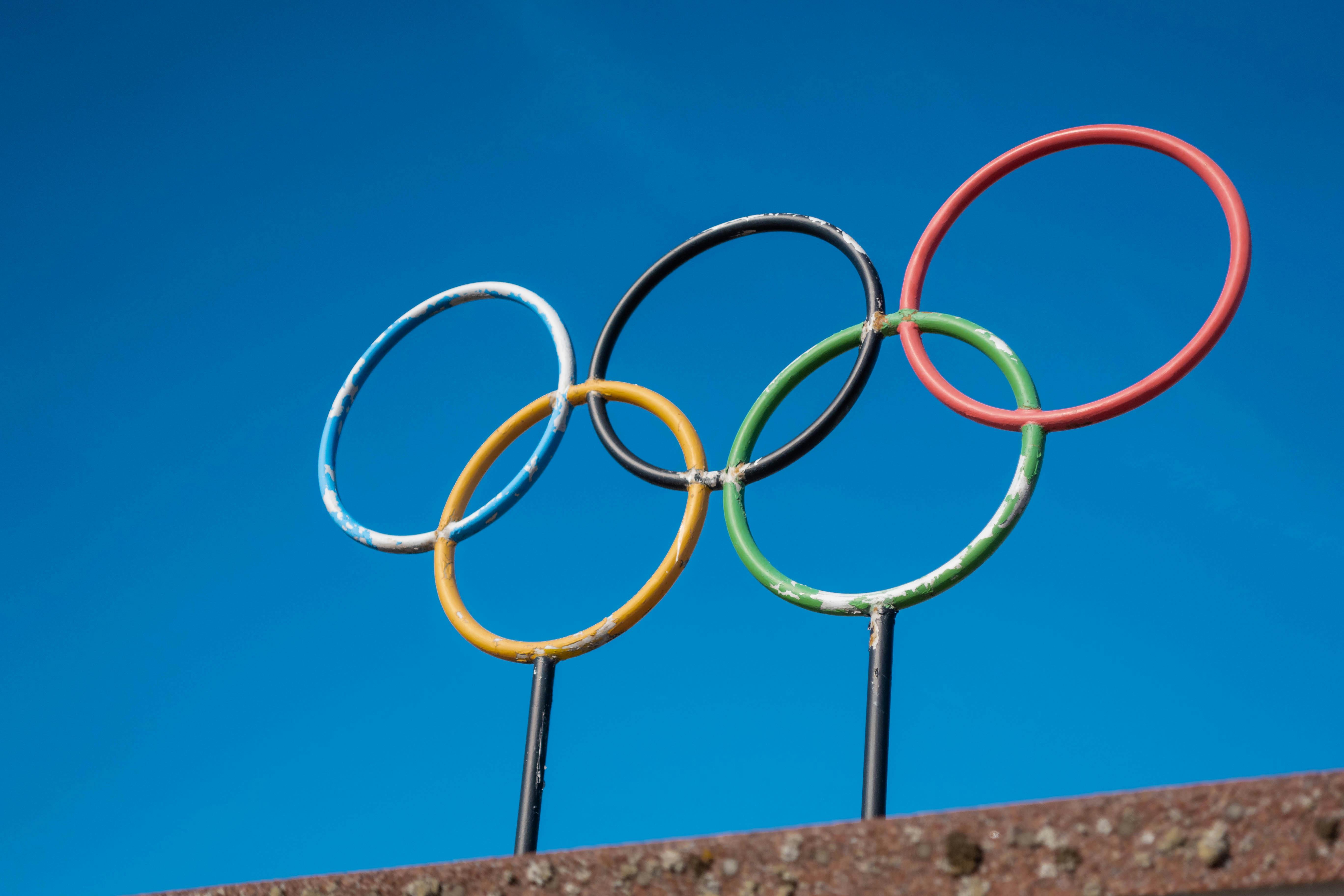 Olympic rings sculpture against a clear blue sky.